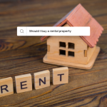 Image of tiny wooden craft house on wood table with the word "Rent" spelled out in Scrabble letters, along with an internet search box with the phrase "Should I buy a rental property"